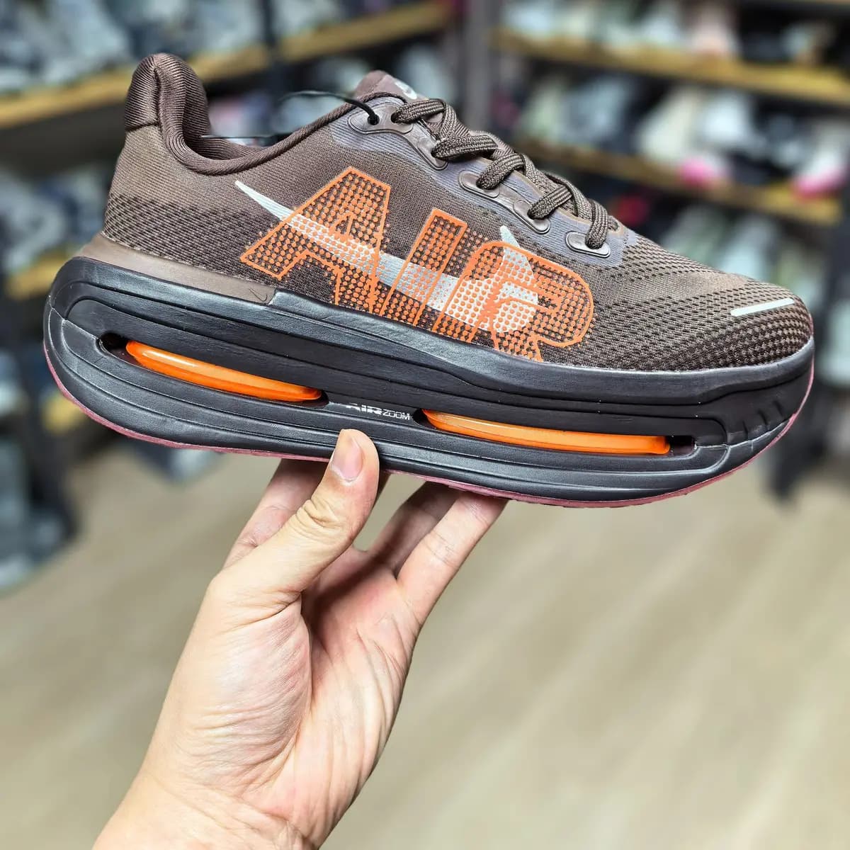 Nike Vomero Premium marrom, marrom e laranja, no pé